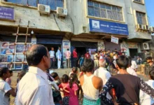 सुरेंद्र यादव के भवन में स्थित एक्सिस बैंक शाखा के बाहर आग लगने की घटना के बाद जमा हुई भीड़